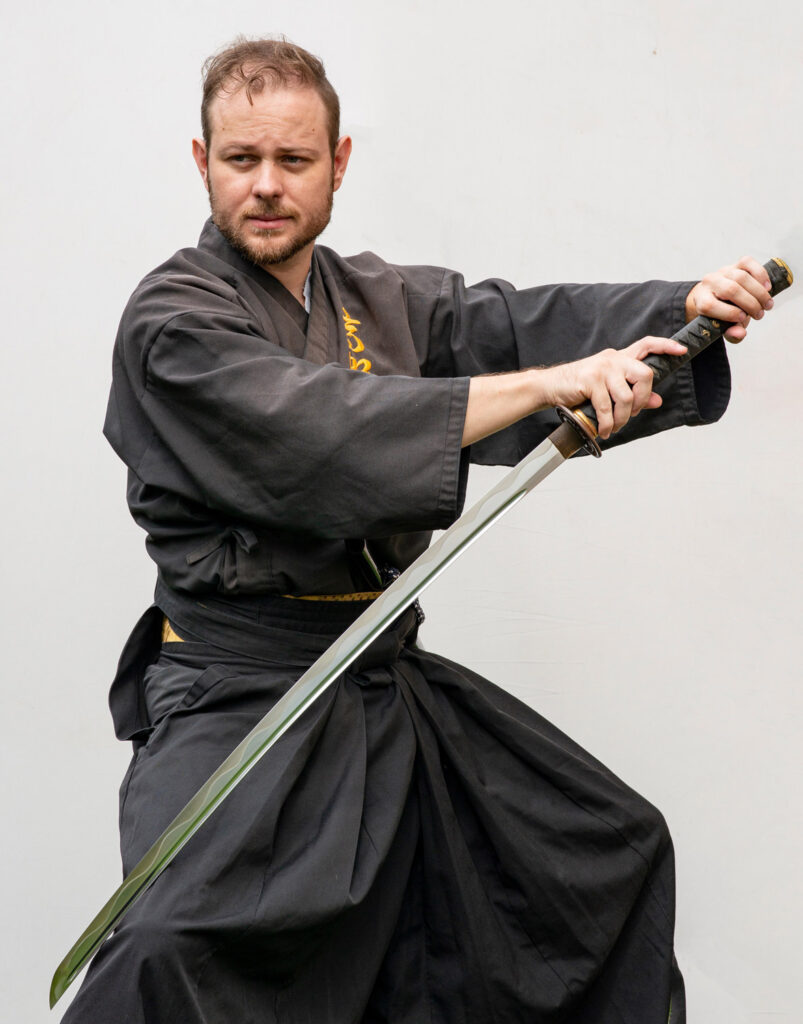 Sebastijan Sekol beim Chiburi (Blutreinigungstechnik) mit Katana in schwarzer Uniform – Iaijutsu Schwertkunst Graz